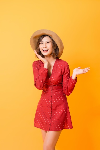 Jeune femme asiatique montrant les mains et posant sur fond orange