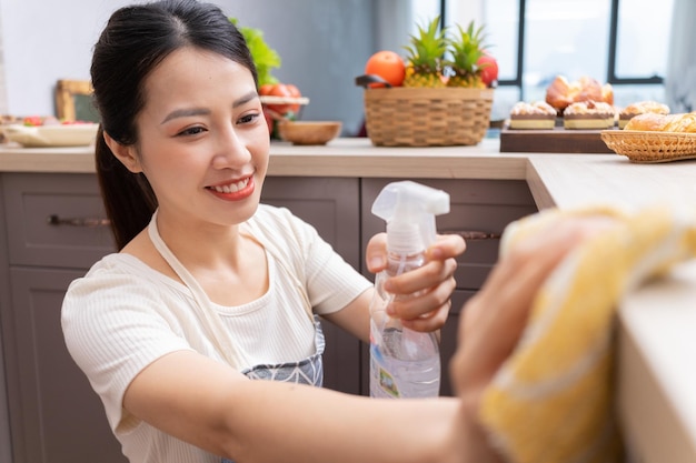 Jeune femme asiatique nettoyant la cuisine après la cuissonxA