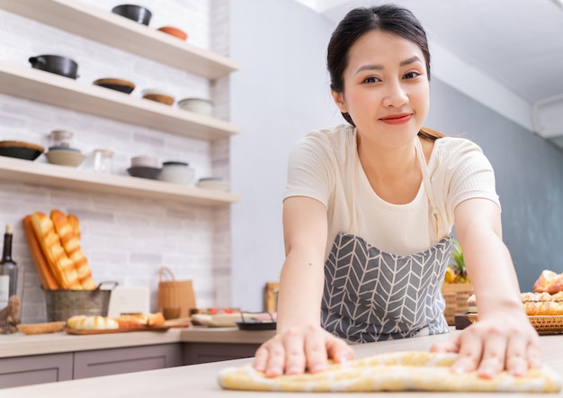 Jeune femme asiatique nettoyant la cuisine après la cuissonxA