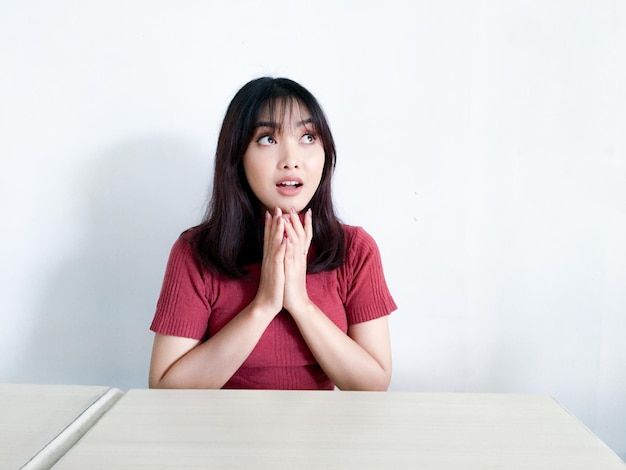 Jeune femme asiatique pensant geste regardant au-dessus isolé sur fond blanc