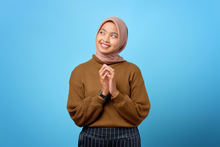 La jeune femme asiatique pensive a l'air de penser sérieusement à une question sur fond bleu