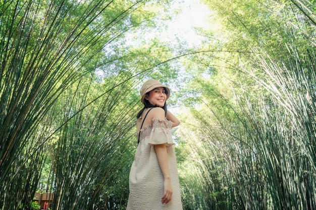 Jeune femme asiatique portant un chapeau debout dans la forêt de bambous à la campagne