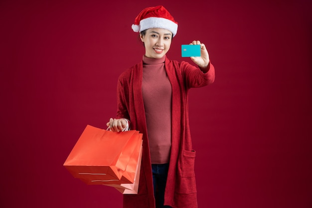 Jeune Femme Asiatique Portant Un Chapeau De Noël Sur Fond Rouge