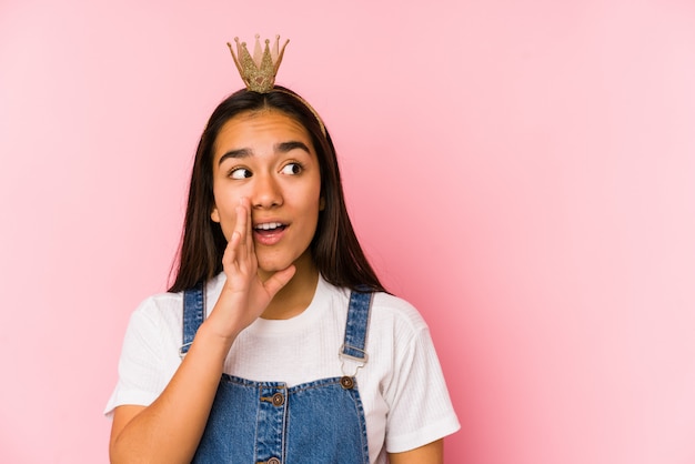 Jeune femme asiatique portant une couronne dit une nouvelle secrète sur le freinage et regarde de côté