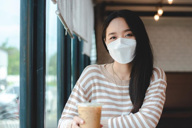 Jeune femme asiatique portant un masque chirurgical pour un nouveau mode de vie normal vivant en ville urbaine