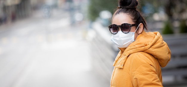 jeune femme asiatique portant un masque pour empêcher les germes, les fumées toxiques et la poussière