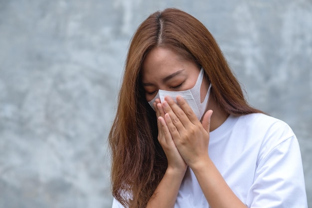 Une jeune femme asiatique portant un masque protecteur et tombant malade pour le concept de soins de santé et Covid19