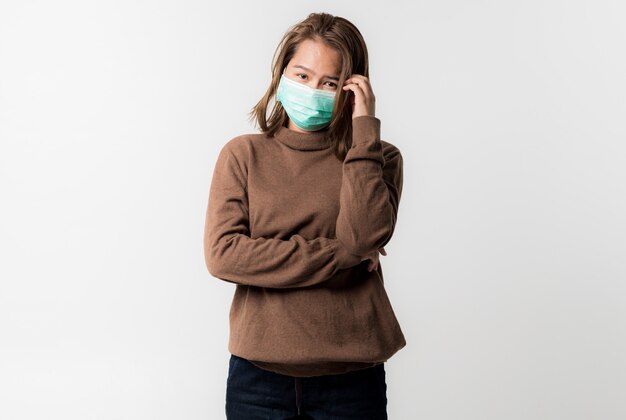 Jeune femme asiatique portant un masque de protection d'hygiène sur son visage sur fond blanc, Coronavirus Covid-19