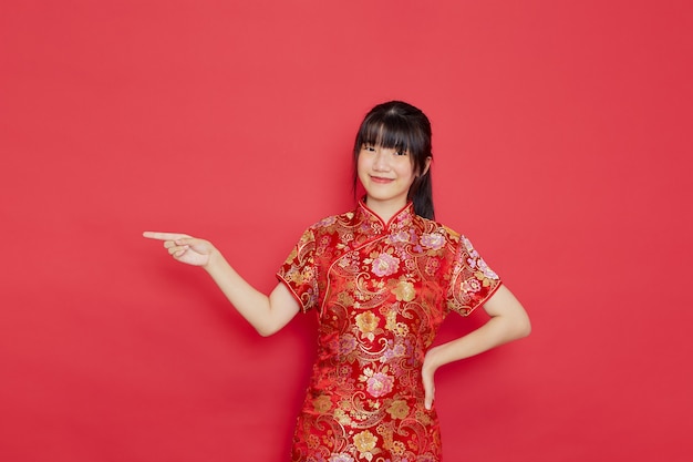 Jeune femme asiatique portant une robe cheongsam et pointant