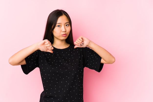 Jeune femme asiatique portant des vêtements élégants isolés se sent fière et confiante, exemple à suivre.