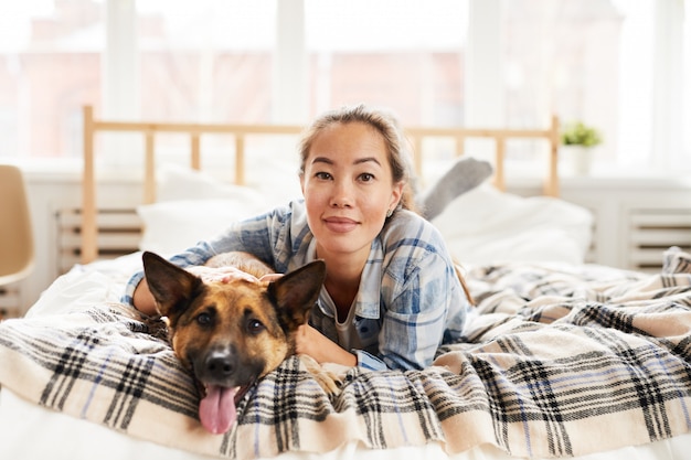 Jeune, femme asiatique, poser, à, chien, lit