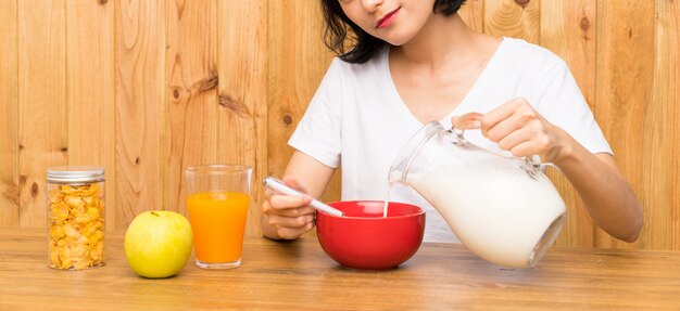 Jeune femme asiatique prenant son petit déjeuner