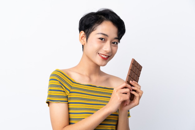 Jeune, femme asiatique, prendre, a, tablette chocolat, et, heureux