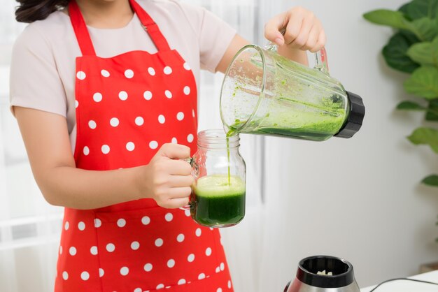 Une jeune femme asiatique profite d'un smoothie végétarien sain pour perdre du poids et se désintoxiquer