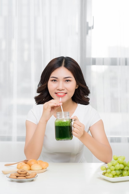 Une jeune femme asiatique profite d'un smoothie végétarien sain pour perdre du poids et se désintoxiquer