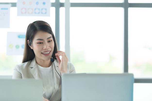 Une jeune femme asiatique qui travaille dans un centre d'appels en tant que consultante sur les investissements en actions.