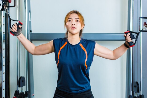 Jeune femme asiatique qui travaille et faire de l&#39;entraînement physique dans une salle de sport locale