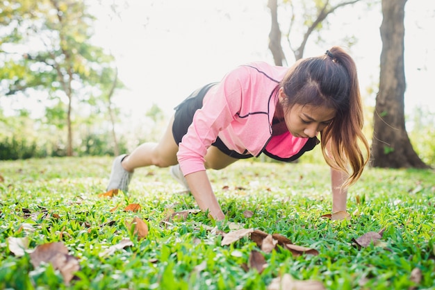 Jeune femme asiatique réchauffe son corps en poussant pour augmenter sa force