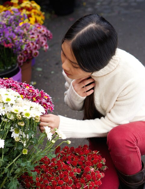 Jeune femme asiatique en regardant les fleurs au magasin