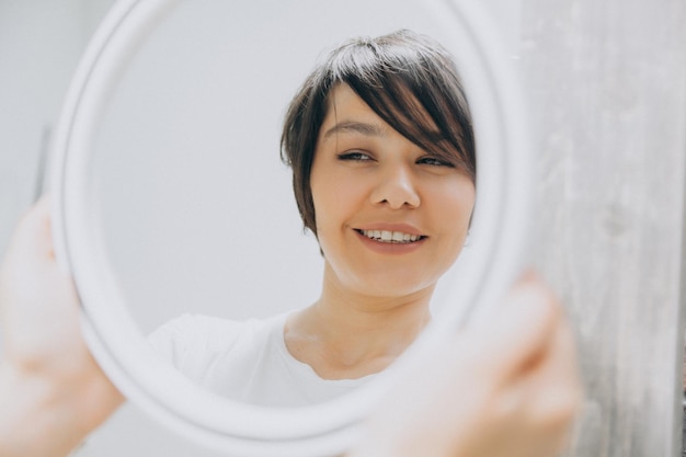 Jeune femme asiatique regardant son reflet dans le miroir