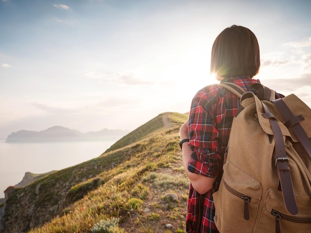 Une jeune femme asiatique avec un sac à dos en randonnée en été