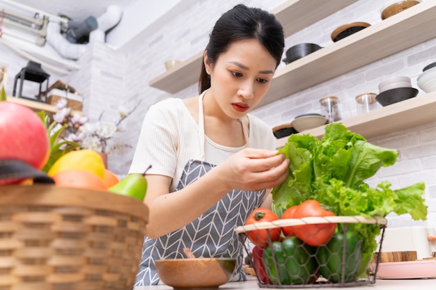 Photo jeune femme asiatique se préparant à cuisiner dans la cuisinexa