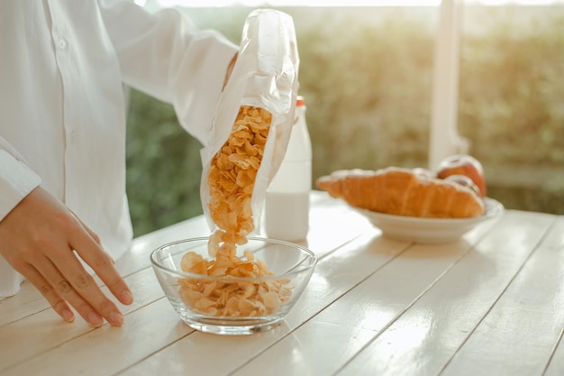 Jeune femme asiatique se réveille rafraîchie le matin et se détend en mangeant du café, des cornflakes, du pain et des pommes pour le petit-déjeuner à la maison en vacances. Asiatique, asie, détente, petit-déjeuner, rafraîchissement, concept de style de vie.