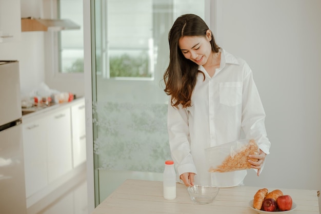 Jeune Femme Asiatique Se Réveille Rafraîchie Le Matin Et Se Détend En Mangeant Du Café, Des Cornflakes, Du Pain Et Des Pommes Pour Le Petit-déjeuner à La Maison En Vacances. Asiatique, Asie, Détente, Petit-déjeuner, Rafraîchissement, Concept De Style De Vie.