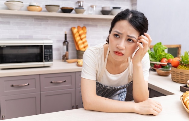 Jeune femme asiatique se sentant fatiguée des travaux ménagersxA