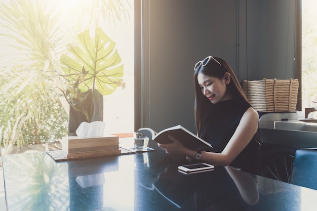 Jeune, femme asiatique, séance, apprécier, lecture, livre, quoique, délassant