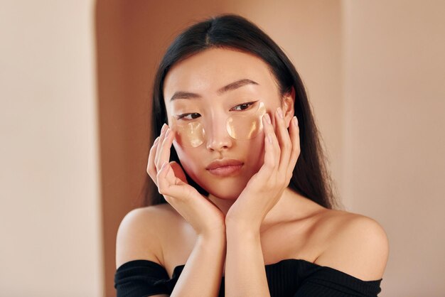 Jeune femme asiatique sérieuse debout à l'intérieur