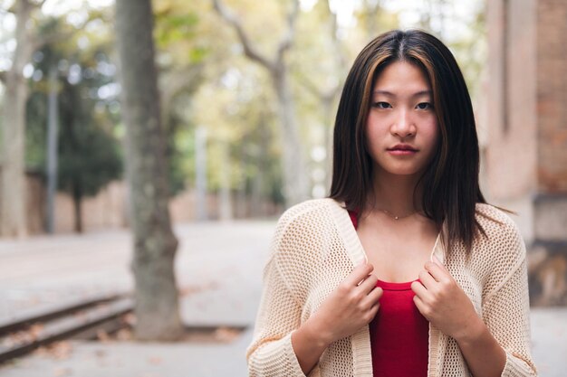 Jeune femme asiatique sérieuse regardant la caméra