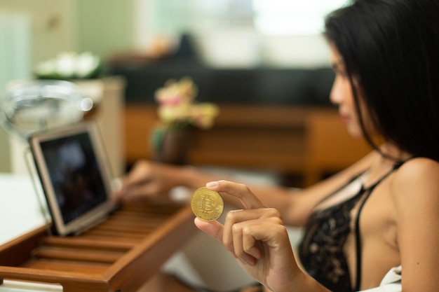 Jeune femme asiatique sexy des années 20 commerce crypto-monnaie btc bitcoin sur tablette numérique internet en lingeries