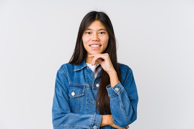 Jeune femme asiatique souriante heureuse et confiante, touchant le menton avec la main.