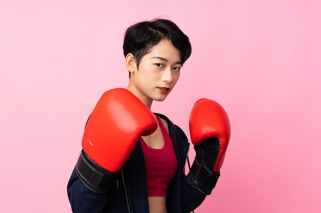 Jeune femme asiatique de sport avec des gants de boxe