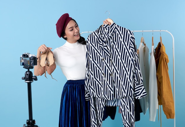 Photo une jeune femme asiatique en streaming en direct pour la vente de vêtements de mode est une blogueuse présentant pour les personnes sociales. elle est une influenceuse sur les réseaux sociaux en ligne.