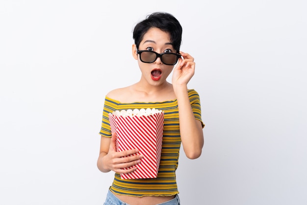 Jeune femme asiatique surprise avec des lunettes 3d et tenant un gros seau de pop-corn