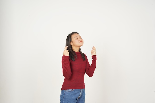 Jeune femme asiatique en T-shirt rouge croisant le doigt Le doigt de la chance isolé sur fond blanc