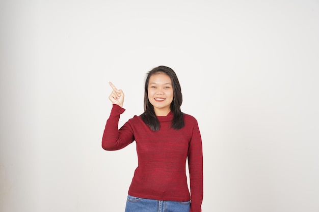 Jeune femme asiatique en t-shirt rouge pointant vers l'espace de copie latéral isolé sur fond blanc