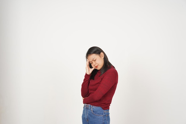 Jeune femme asiatique en t-shirt rouge souffrant de maux de tête geste isolé sur fond blanc