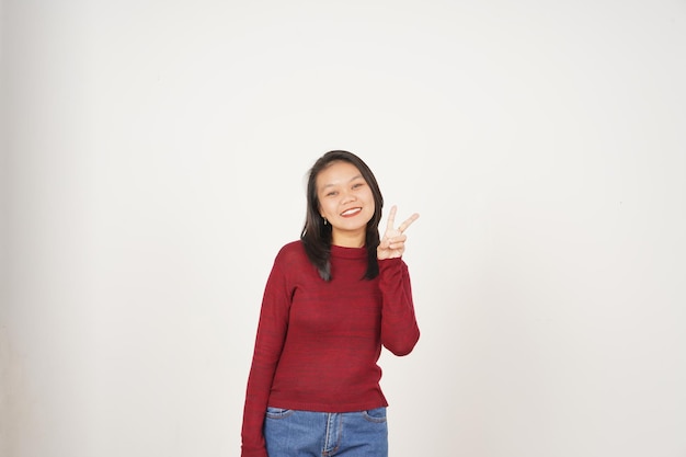 Jeune femme asiatique en t-shirt rouge souriante et montrant un signe de paix ou de victoire montrant isolée sur fond blanc