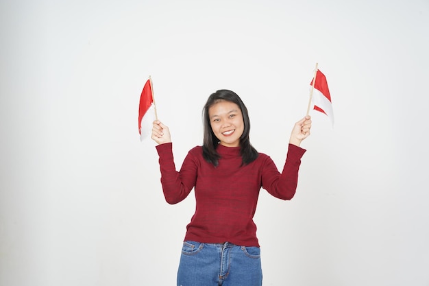 Jeune femme asiatique en t-shirt rouge tenant le drapeau indonésien Concept de la fête de l'indépendance isolé sur fond blanc