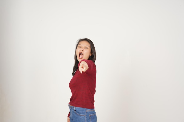 Une jeune femme asiatique en t-shirt rouge vous pointe avec un geste en colère isolé sur un fond blanc