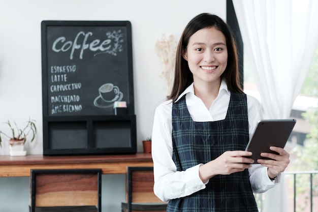 Jeune femme asiatique avec tablette au café