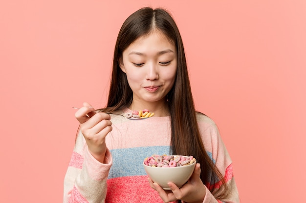 Jeune femme asiatique tenant un bol de céréales