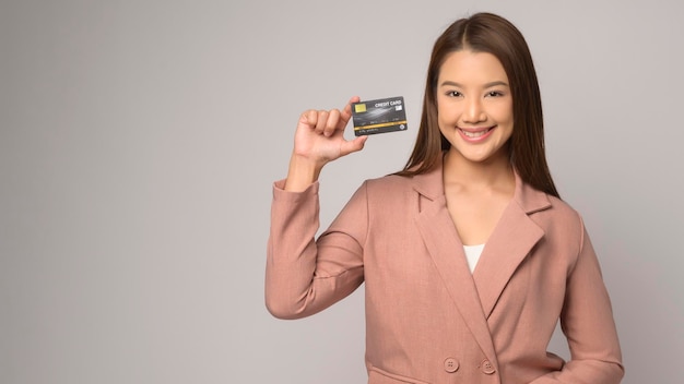 Jeune Femme Asiatique Tenant Une Carte De Crédit Sur Fond Blanc Studio Shopping Et Concept Financier