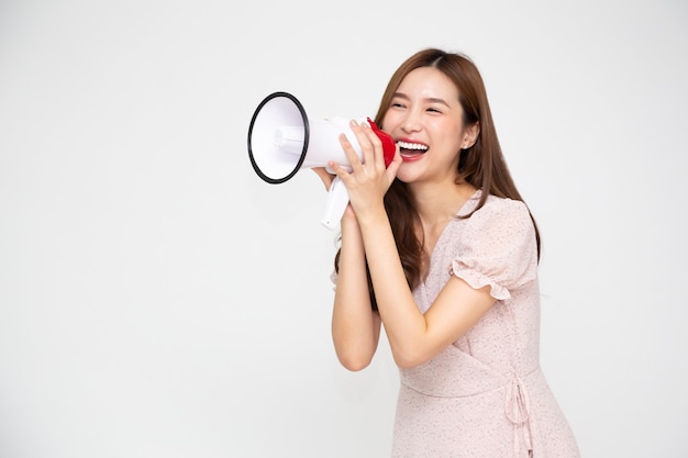 Jeune femme asiatique tenant un mégaphone isolé sur fond blanc.