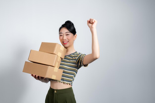 Une jeune femme asiatique travaillant dans une petite entreprise de commerce électronique célèbre son succès avec enthousiasme.