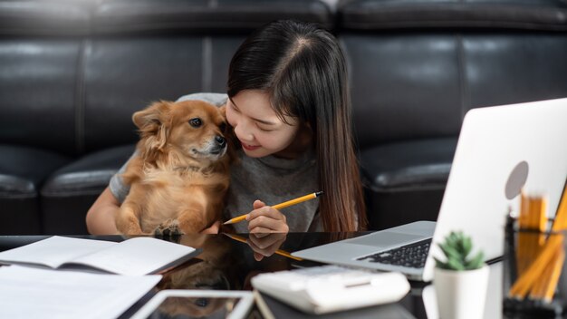 jeune femme asiatique travaillant à distance de la maison et souriant en position couchée