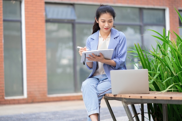 Jeune femme asiatique travaillant à l'extérieur